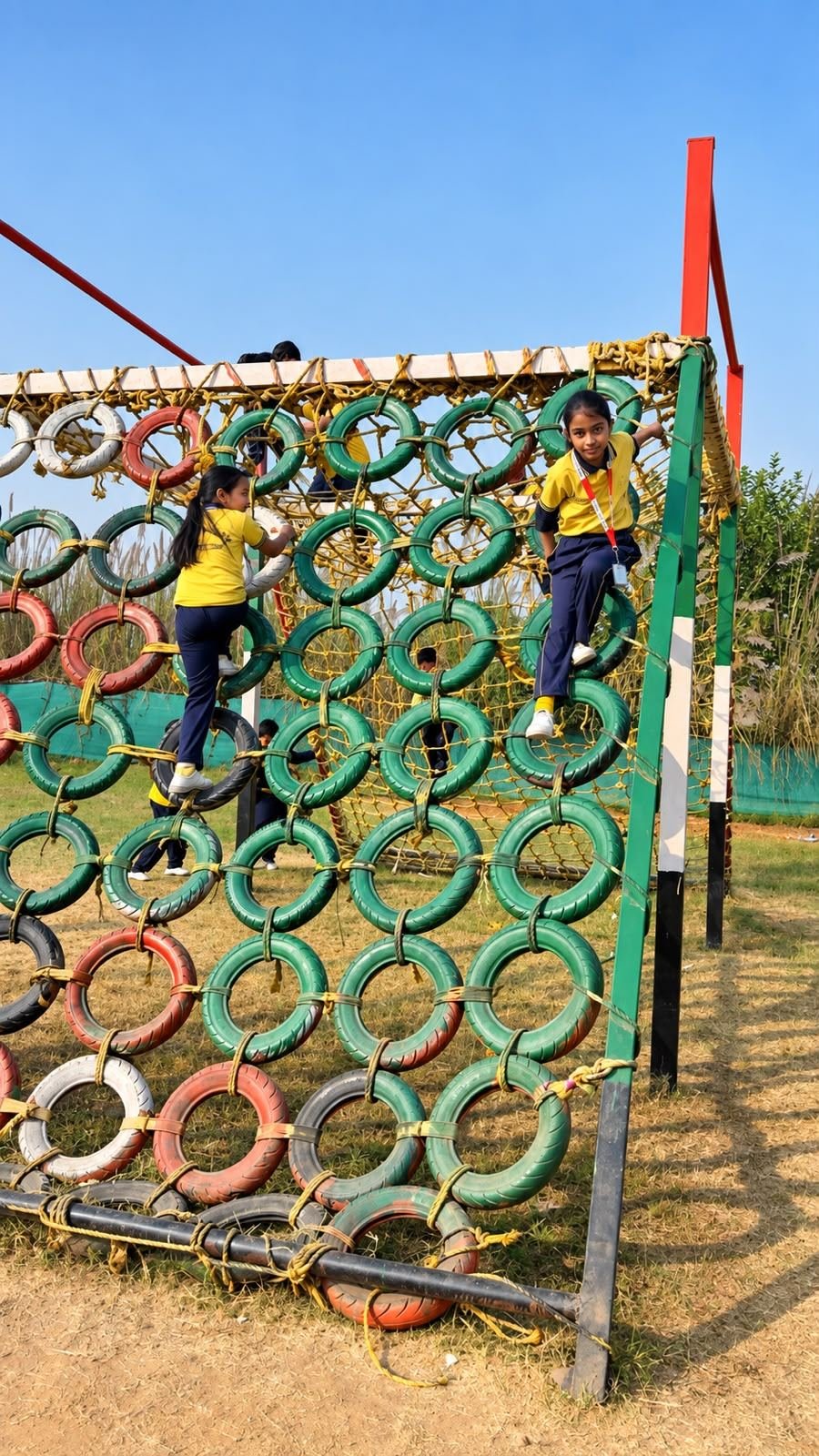 Students climbing a tyre play structure on the GVIS playground