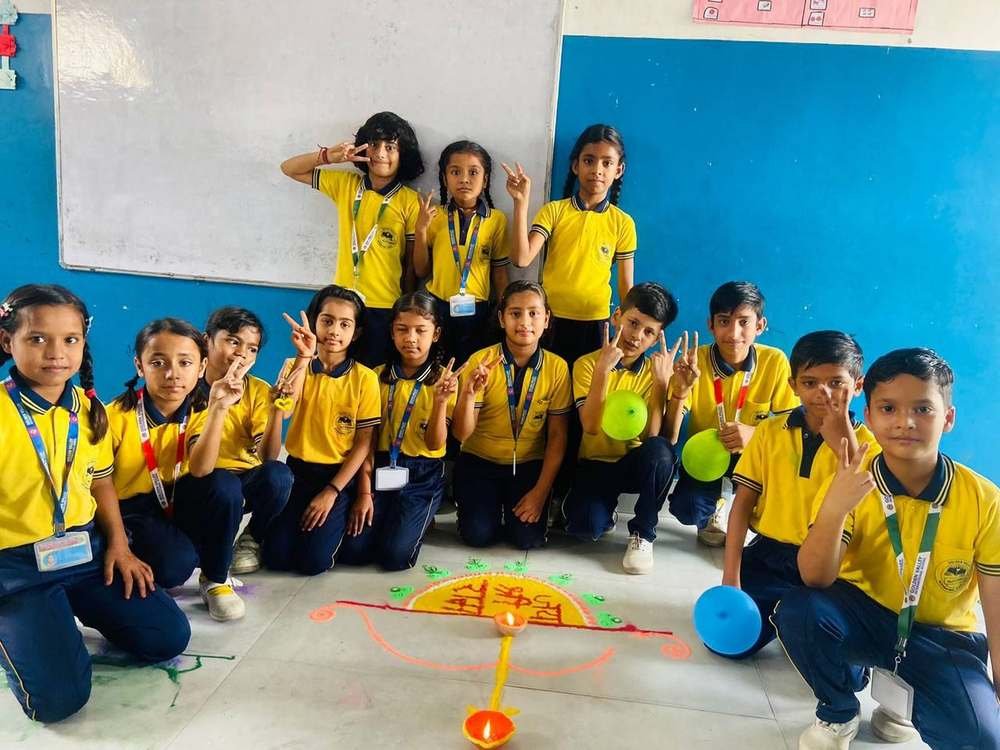 Class group photo with completed Diwali rangoli